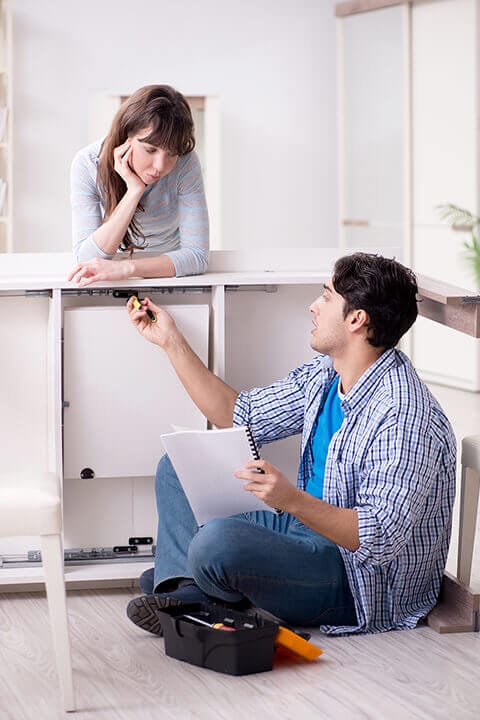Couple frustrated assembling IKEA furniture